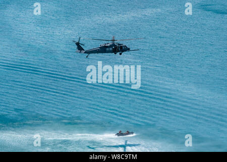 Ein HH-60G Pave Hawk vom 33. Rescue Squadron, senkt eine pararescuemen in ein Schiff im Meer während einer Operation, 26. Juli 2019, aus der Kadena Air Base, Japan. Mitglieder des 33. und 31. Rescue Staffeln von Kadena AB Bahnhof und arbeiten zusammen, um Unterstützung für den Kampf zur Rettung und Katastrophenhilfe zur Verfügung zu stellen. (U.S. Air Force Foto von Airman 1st Class Matthew Seefeldt) Stockfoto