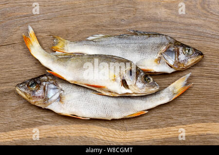 Drei getrocknete Fische auf einem vintage Holz- bacground. Stockfoto