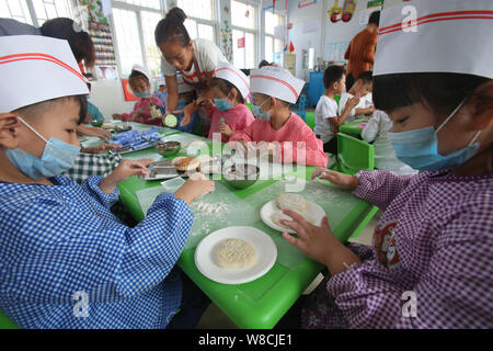 Ein chinesischer Lehrer beauftragt Kinder mooncakes für die Mitte zu machen - Herbst Festival in einem Kindergarten in Tianjin City, Central China Provinz Henan, Stockfoto