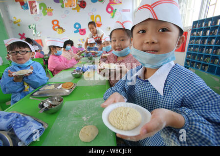 Chinesische Kinder zeigen die Mooncakes sie für die Mitte Herbst Festival in einem Kindergarten in Tianjin City, Chinas Provinz Henan, 25 Septem Stockfoto