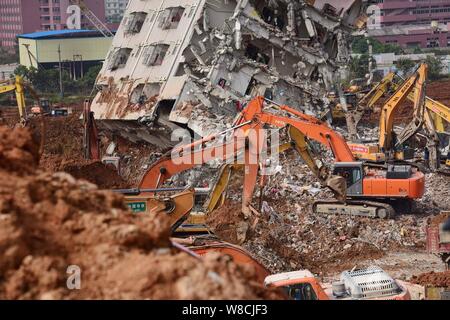 Maschinen werden verwendet, um einem eingestürzten Gebäude auf dem Gelände der Erdrutsch, der die Hengtaiyu, Liuxi und Dejicheng Industrieparks Hit zu demontieren, in Stockfoto