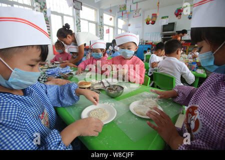 Chinesische Kinder machen mooncakes für Mid Autumn Festival in einem Kindergarten in Tianjin City, Central China Provinz Henan, 25. September 2015. Zu Stockfoto