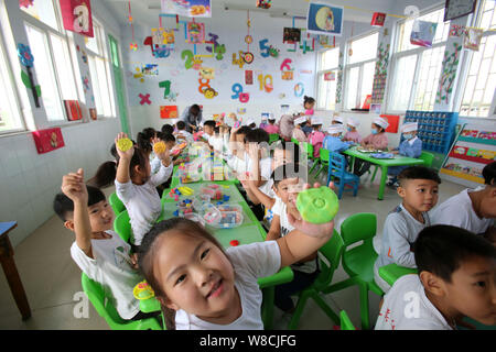 Chinesische Kinder zeigen die Mooncakes sie für die Mitte Herbst Festival in einem Kindergarten in Tianjin City, Chinas Provinz Henan, 25 Septem Stockfoto