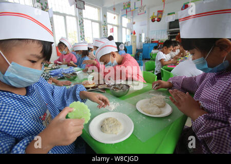 Chinesische Kinder machen mooncakes für Mid Autumn Festival in einem Kindergarten in Tianjin City, Central China Provinz Henan, 25. September 2015. Zu Stockfoto