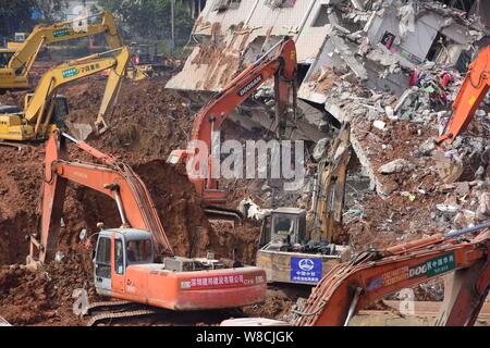 Maschinen werden verwendet, um einem eingestürzten Gebäude auf dem Gelände der Erdrutsch, der die Hengtaiyu, Liuxi und Dejicheng Industrieparks Hit zu demontieren, in Stockfoto