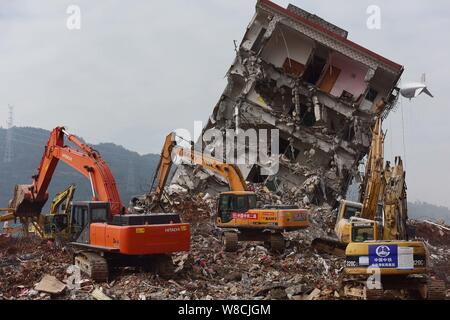 Maschinen werden verwendet, um einem eingestürzten Gebäude auf dem Gelände der Erdrutsch, der die Hengtaiyu, Liuxi und Dejicheng Industrieparks Hit zu demontieren, in Stockfoto