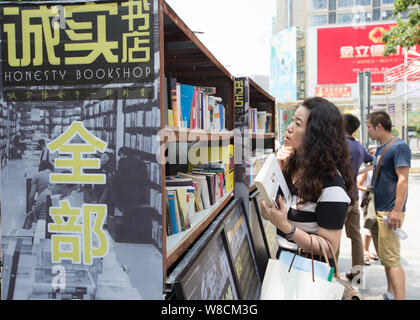 Kunden Shop für Bücher an der staffless Ehrlichkeit Buchhandlung in Nanjing Xinjiekou Straße, Stadt, der ostchinesischen Provinz Jiangsu, 28. Juli 2015. Eine pecul Stockfoto