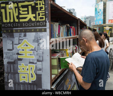 Kunden Shop für Bücher an der staffless Ehrlichkeit Buchhandlung in Nanjing Xinjiekou Straße, Stadt, der ostchinesischen Provinz Jiangsu, 28. Juli 2015. Ein Pecu Stockfoto