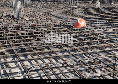 Orange hardhat auf den Stahl Raster von Wohngebäuden Grundlage Verstärkung. Stockfoto