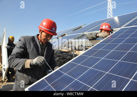 ------ Chinesische Arbeiter installieren Solaranlagen mit einer Photovoltaik (PV)-Kraftwerk in der Stadt Zaozhuang, Provinz Shandong, China vom 22. Dezember 2014. Stockfoto