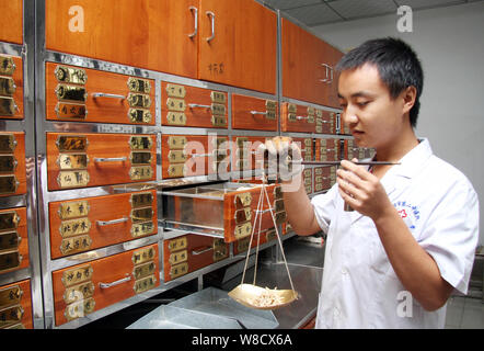 ---- Eine Chinesische pharmaceutist verzichtet der Traditionellen Chinesischen Medizin bei einer TCM-Apotheke in Luoyang City, Central China Provinz Henan, 12. September Stockfoto