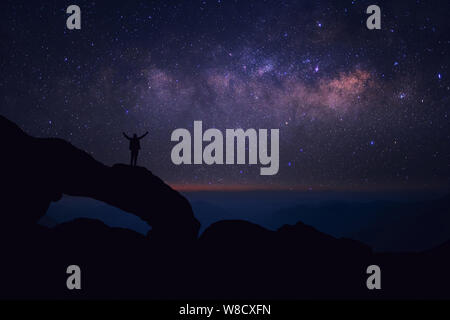 Mann, der an der Spitze der Welt an der Milchstraße suchen fühlt Stockfoto