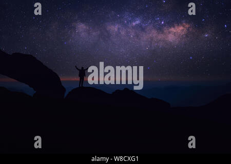 Mann, der an der Spitze der Welt an der Milchstraße suchen fühlt Stockfoto