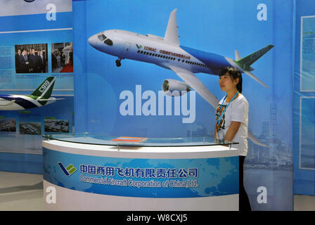 ---- Ein chinesischer Mitarbeiter ist auf dem Stand der COMAC (Commercial Aircraft Corporation von China, Ltd.) Während der Shanghai Design Biennale 2012 in gesehen Stockfoto