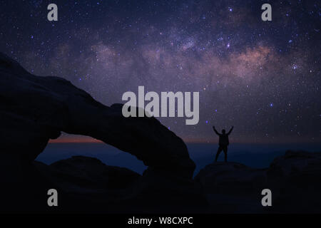 Mann, der an der Spitze der Welt an der Milchstraße suchen fühlt Stockfoto