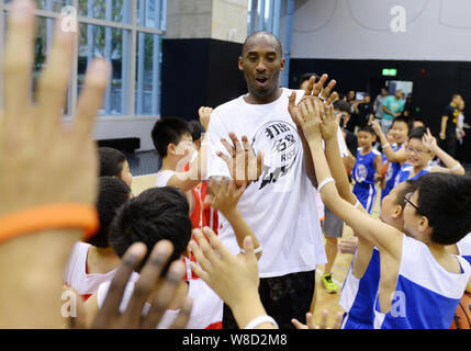 Basketball NBA-Star Kobe Bryant interagiert mit chinesischen Kindern an einem Basketball event während seiner Reise nach China in Guangzhou City, South China Guangdong Stockfoto