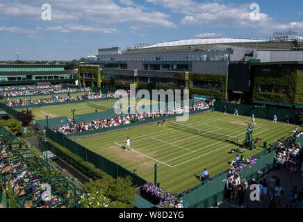 Ansicht der Zuschauer spielen außerhalb der Gerichte mit Center Court im Hintergrund, während sie 2019 Wimbledon Championships, London, England, Stockfoto