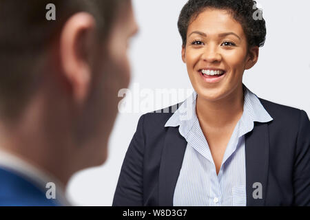 Studio Shot der Geschäftsfrau interviewen Geschäftsmann für Beschäftigung vor weißem Hintergrund Stockfoto