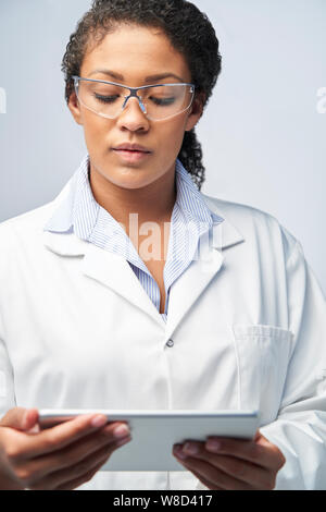 Studio Shot der weiblichen Labor Techniker arbeiten mit digitalen Tablet Stockfoto