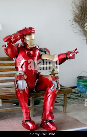 Ein Freund von Chinesischen 'Iron Man' fan Cheng Chen in Cheng's hausgemachte Kunststoff Iron Man Rüstung an seinem Haus in Xuzhou Stadt gekleidet ist, wird der Osten China Jiangsu p Stockfoto
