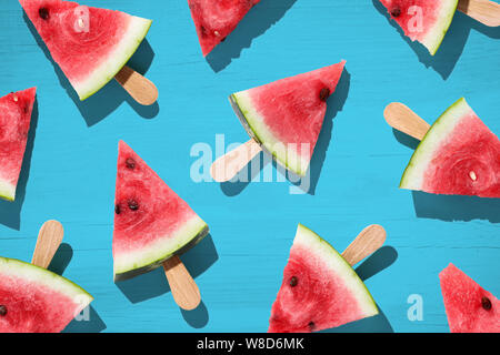 Wassermelone in Scheiben geschnitten auf farbigen Hintergrund. Ansicht von oben Stockfoto