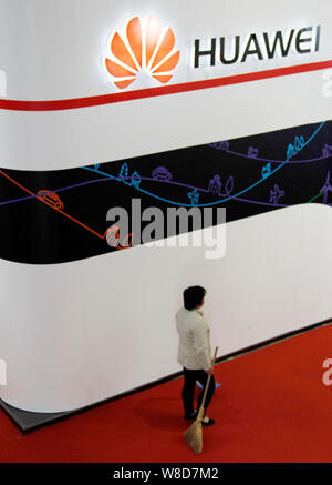 --FILE - eine Reinigung Arbeitnehmer Spaziergänge hinter den Stand von Huawei während einer Messe in Peking, China, 30. Oktober 2014. Huawei Technologies hat einen Kern Stockfoto