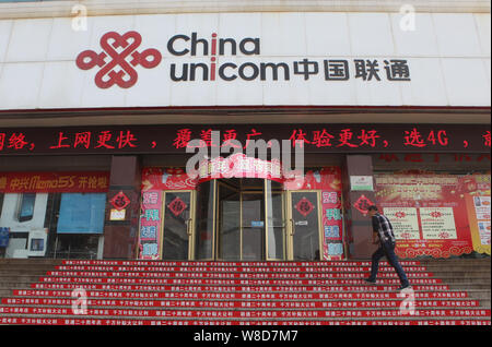 ---- Ein Kunde geht auf einen Zweig von China Unicom in Rizhao Stadt, im Osten der Provinz Shandong, China 21. April 2015. China Unicom am Donnerstag Stockfoto