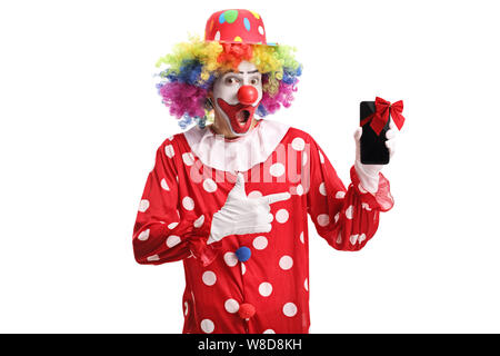 Glücklich lächelnde Clown mit Handy mit einem roten Pfeil und Bogen auf Sie zeigen isoliert auf weißem Hintergrund Stockfoto