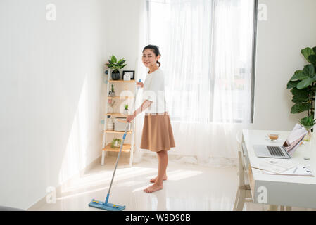 Junge asiatische Frau tun Reinigung im Home Office. Stockfoto