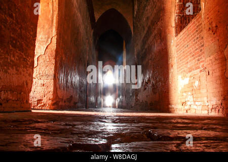 Hohe Flur in der dunkel mit hellen Fenstern am Ende in Bagan, Myanmar/Burma. Stockfoto