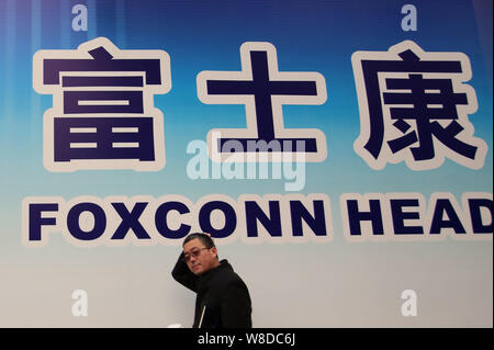 ---- Einen Fußgänger an einem Namensschild des Foxconn zentrale Gebäude im Bau in Pudong, Shanghai, China, 6. Februar 2015. Fox Stockfoto