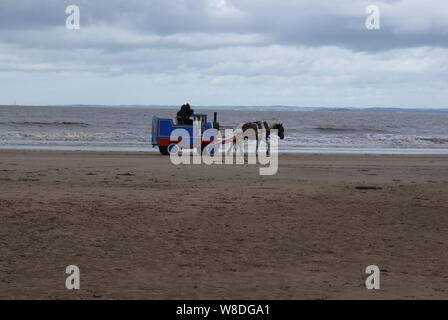 Ein Thomas die Lok Zug entlang durch ein Pony von Weston-super-Mare Beach gezogen wird. Stockfoto