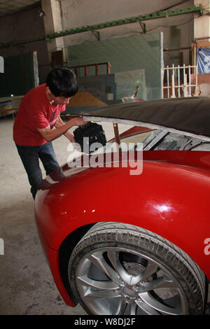 Junge Chinesen Chen Yinxi seine hausgemachten elektrischen Sportwagen in der Werkstatt der Familie Fabrik in Stadt Haikou Schecks, South China Hainan provin Stockfoto