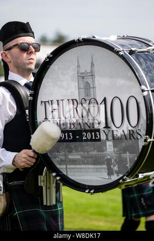 Bass Drummer in Thurso Pipe Band spielen an der Halkirk Highland Games in Caithness, Schottland Stockfoto