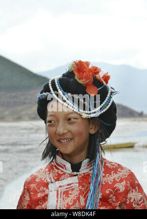 --FILE - ein chinesisches Mädchen der Mosuo ethnische gruppe Lächeln an der Bank der Lugu See in Lijiang, im Südwesten der chinesischen Provinz Yunnan, 28. Februar 2015. Die tr Stockfoto