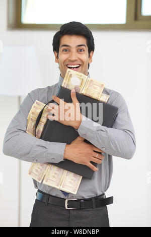 Geschäftsmann mit Banknoten und Aktenkoffer Stockfoto