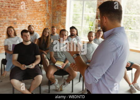 Sprecher männlich eine Präsentation halten an der Universität Workshop. Publikum oder Konferenzraum. Mit Tafel und Flipchart zur Visualisierung von Informationen. Wissenschaftliche Konferenz, Schulung. Bildung. Stockfoto