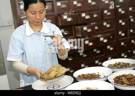 ---- Eine Chinesische pharmaceutist verzichtet der Traditionellen Chinesischen Medizin bei einer TCM-Apotheke in Shanghai, China, 14. November 2011. Kanglaite Injektion ( Stockfoto