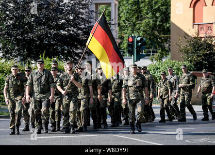 Potsdam, Deutschland. 08 Aug, 2019. Soldaten der Bundeswehr tragen eine deutsche Flagge und März durch eine Straße in Potsdam. Quelle: Britta Pedersen/dpa-Zentralbild/dpa/Alamy leben Nachrichten Stockfoto