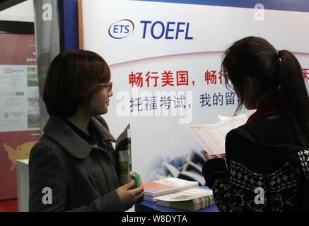 ---- Besucher lesen Broschüren an einem Stand der Toefl (Test von Englisch als Fremdsprache) während der China Education Expo 2012 in Peking, China, 21. Stockfoto