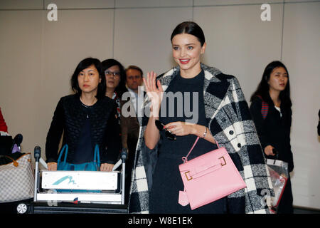 Australische Modell Miranda Kerr, rechts, Wellen, wie sie geht in Richtung Ausgang nach der Landung am Internationalen Flughafen Hong Kong in Hong Kong, China, 9. Stockfoto