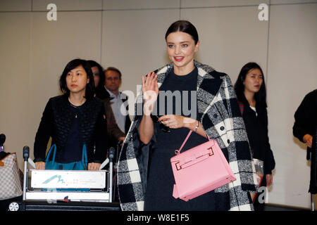 Australische Modell Miranda Kerr, rechts, Wellen, wie sie geht in Richtung Ausgang nach der Landung am Internationalen Flughafen Hong Kong in Hong Kong, China, 9. Stockfoto