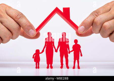 Person schützende Hand Familie Figuren mit Dach Stockfoto