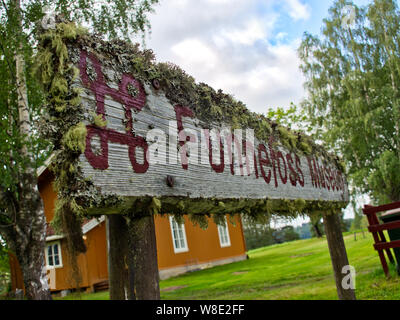 Alte nostalgische Zeichen aus Holz mit Moos gewachsen ist. Stockfoto