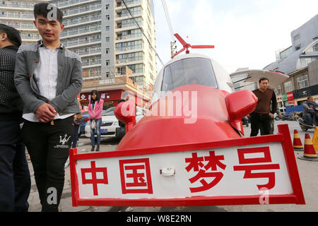 Fußgänger vorbei an den hausgemachten Hubschrauber-förmige Fahrzeug gebaut von pensionierten chinesischen Ingenieur Yuan Jingying auf einer Straße in Zhengzhou City, Central Kinn Stockfoto