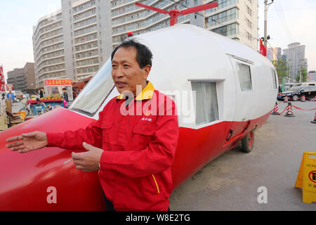 Pensionierte chinesischen Ingenieur Yuan Jingying interviewt wird neben seinem hausgemachten Hubschrauber-förmige Fahrzeug auf einer Straße in Zhengzhou City, Central China Hena Stockfoto