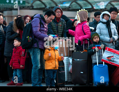 Chinesische Passagiere, die Rückkehr aus dem Chinesischen Neujahrsfest oder Spring Festival warten Taxis zu arbeiten nach dem Verlassen der Beijing Railway Station Beij Stockfoto