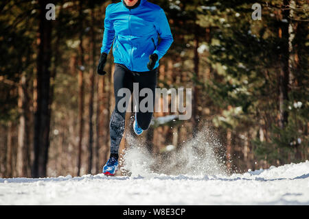 Dynamische auf Winter trail Athlet Läufer in blaue Jacke Stockfoto