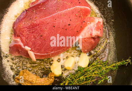 Roastbeef in der Pfanne mit Butter, Knoblauch, Ingwer und Thymian Stockfoto