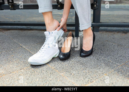 Nahaufnahme der Geschäftsfrau ist sitzt auf der Bank tragen Sie bequeme Schuhe Stockfoto